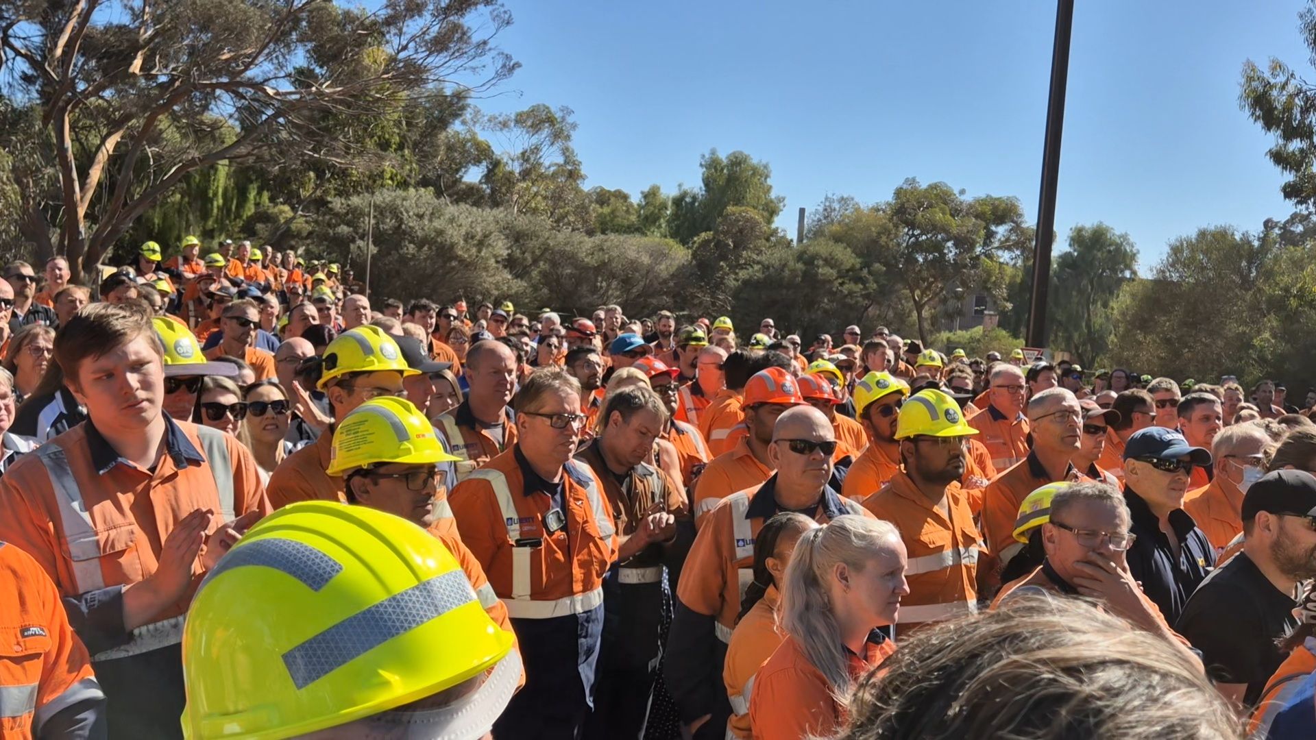 Steelworkers look on as the Premier addresses the crowd