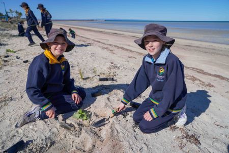 Samaritan Students planting shrubs on beach